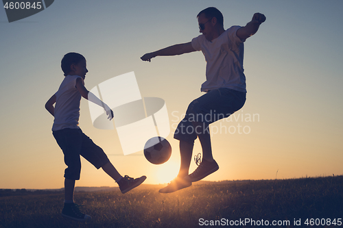 Image of Father and young little boy playing in the field  with soccer ba