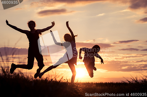 Image of Happy children playing in the park at the sunset time.