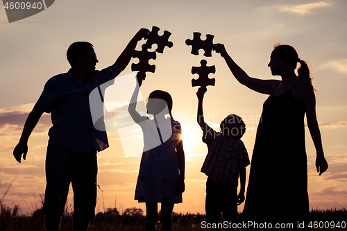 Image of Happy family standing in the park at the sunset time.