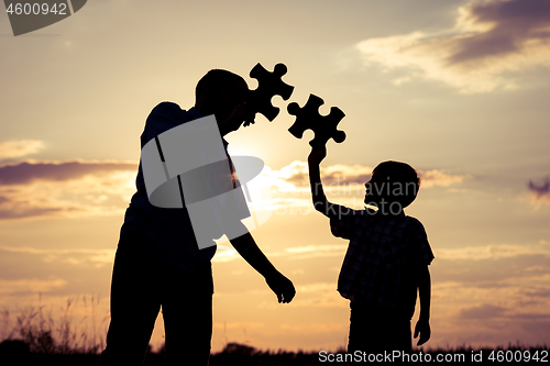 Image of Father and son walking on the field at the sunset time. 