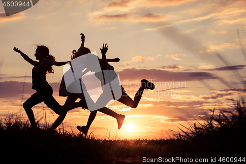 Image of Happy children playing in the park at the sunset time.