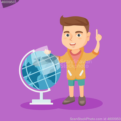 Image of Boy standing near globe and pointing finger up.