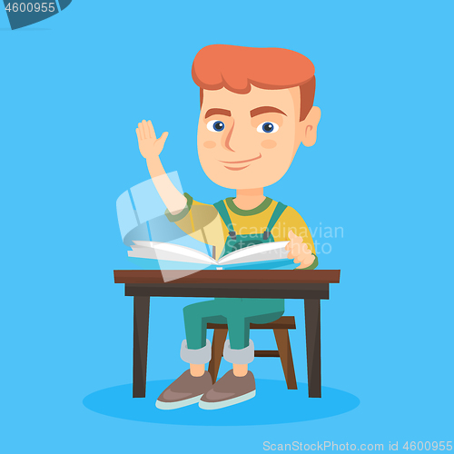 Image of Pupil raising hand while sitting at the desk.