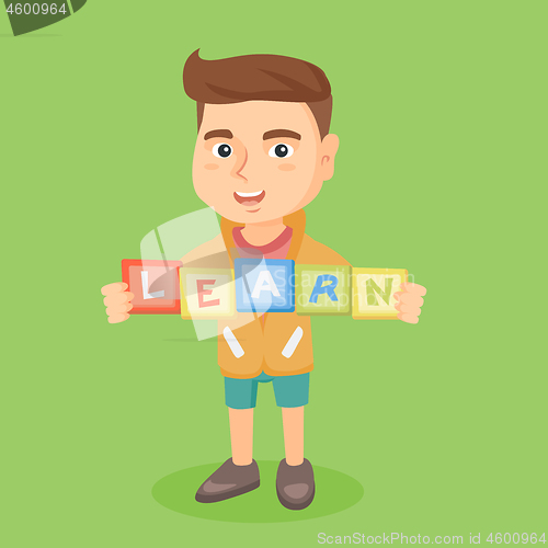 Image of Boy holding blocks that spelling the word learn.