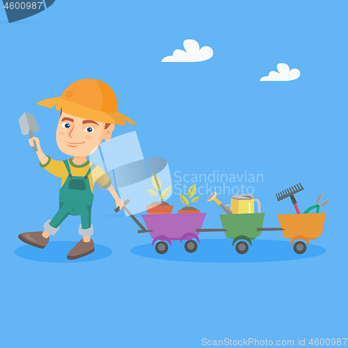 Image of Boy pushing a cart with plants and garden tools.
