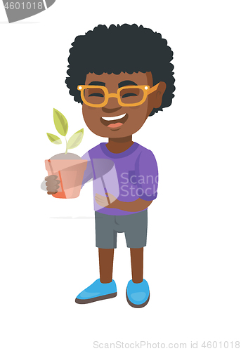 Image of African smiling boy holding a potted plant.