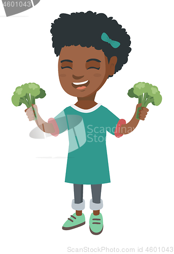 Image of Little african girl laughing and holding broccoli