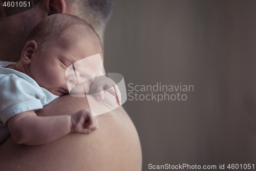 Image of Father holding newborn baby son at the day time.