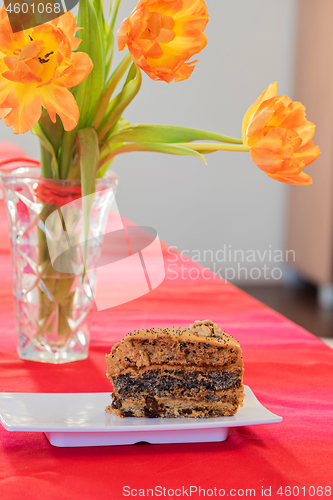 Image of A bouquet of tulips and piece of cake on the table