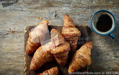 Image of freshly baked croissants on wooden table