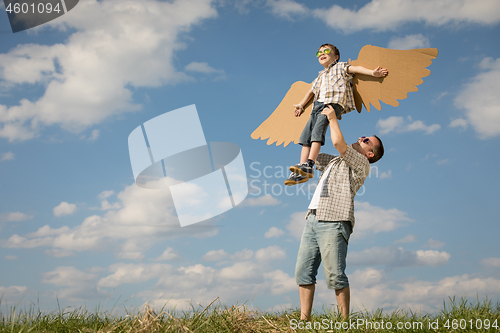 Image of Father and son playing with cardboard toy wings