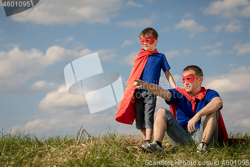 Image of Father and son playing superhero at the day time.