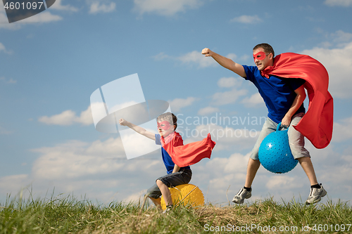 Image of Father and son playing superhero at the day time. 