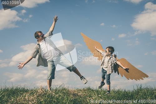 Image of Father and son playing with cardboard toy wings