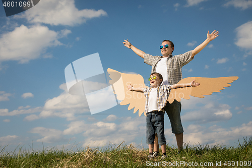 Image of Father and son playing with cardboard toy wings