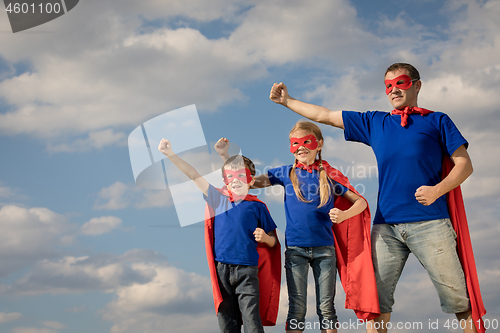 Image of Father and children playing superhero at the day time.