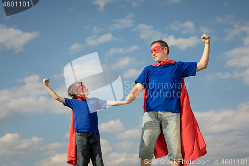 Image of Father and son playing superhero at the day time.