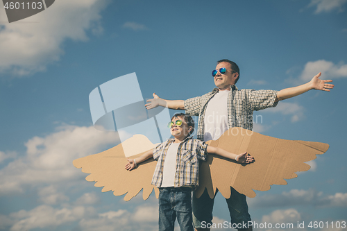 Image of Father and son playing with cardboard toy wings