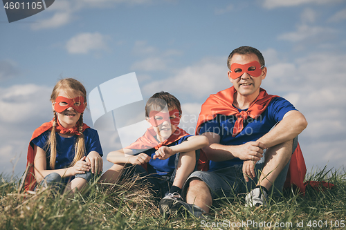 Image of Father and children playing superhero at the day time.