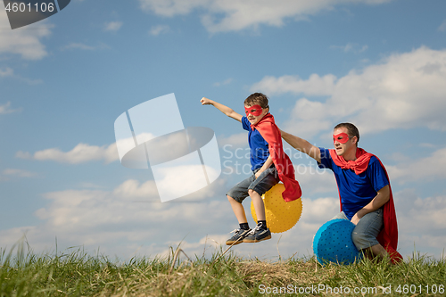 Image of Father and son playing superhero at the day time.