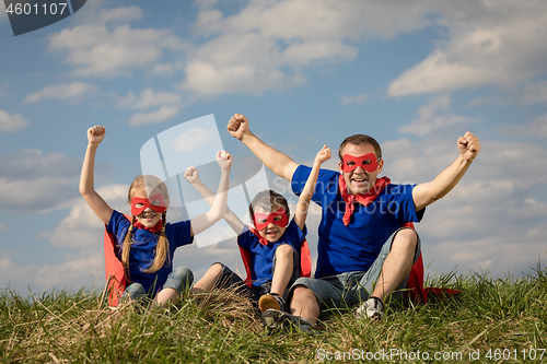 Image of Father and children playing superhero at the day time.