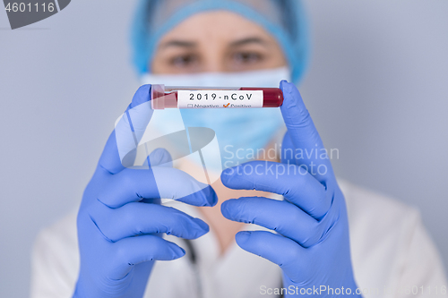 Image of Nurse holding test tube with Positive Coronavirus test blood sam