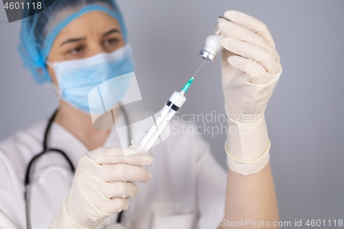 Image of Doctor hands filling the syringe with vaccine