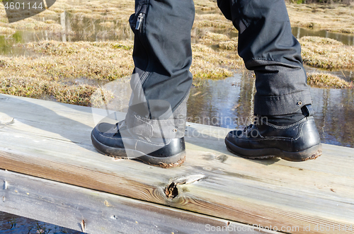 Image of Close up of a hikers footwear on a footbridge