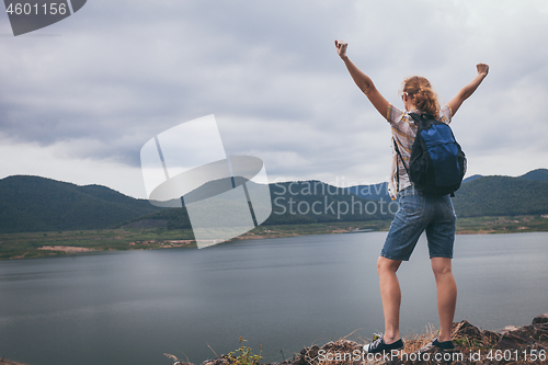 Image of Happy woman standing near the lake at the day time.