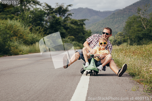 Image of Father and daughter playing  on the road at the day time. 