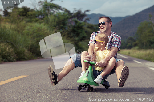 Image of Father and daughter playing  on the road at the day time.