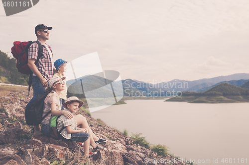 Image of Happy family standing near the lake at the day time.
