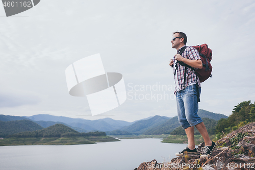 Image of Happy man standing near the lake at the day time.