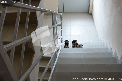 Image of Abandoned shoes stand on the stairs in the entrance