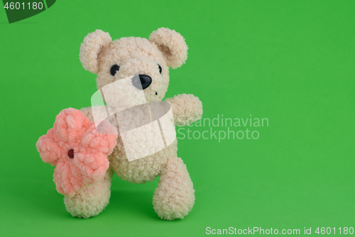 Image of Knitted toy pink mouse on a green background