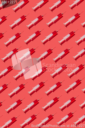 Image of Health-care pattern of disposable syringes with red liquid.