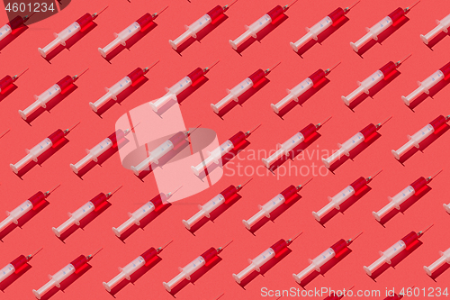 Image of Medicinal pattern from syringes with red liquid or serum.