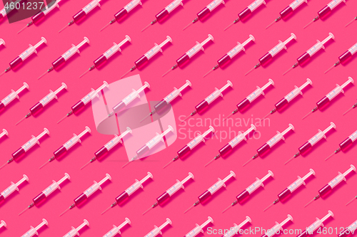 Image of Medicinal pattern from syringes with hot pink drugs or serum.