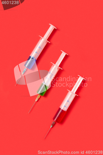 Image of Therapeutic set of sterile plastic syrenges with colorful vaccines.