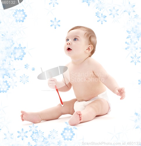 Image of baby boy in diaper with toothbrush