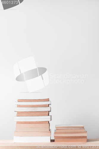 Image of Stacks of books on a wooden shelf