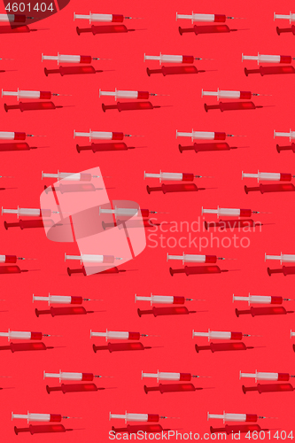 Image of Medicinal pattern of flying syringes with red blood or vaccine.