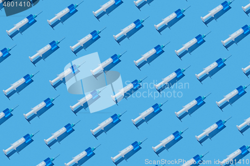 Image of Health-care pattern of disposable syringes with blue liquid.