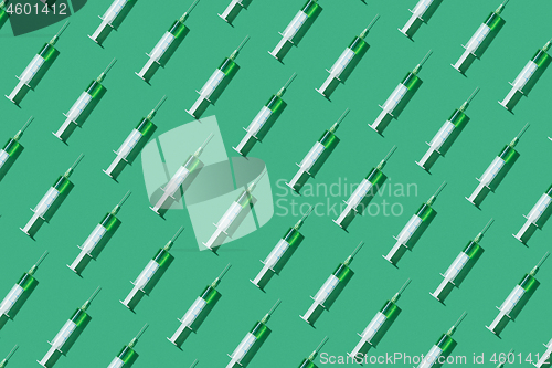 Image of Medicinal pattern from syringes with green drugs or vaccine.