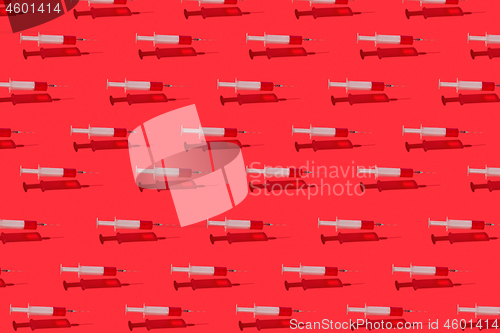 Image of Medical pattern of flying syringes with red blood or vaccine.