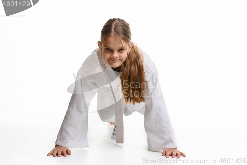 Image of Girl push-UPS from the floor in a sports keikogi