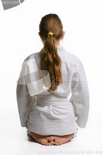 Image of Girl in judo class, sitting on the floor, rear view