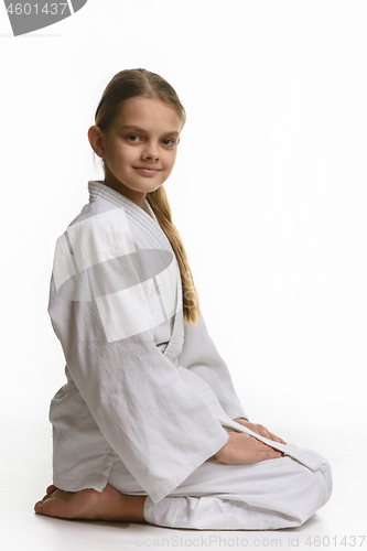 Image of Girl in judo class, sitting on the floor, the view from the side