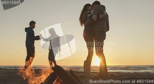 Image of Friends having fun at beach on autumn day