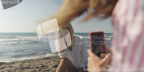 Image of Two girl friends having fun photographing each other on vecation